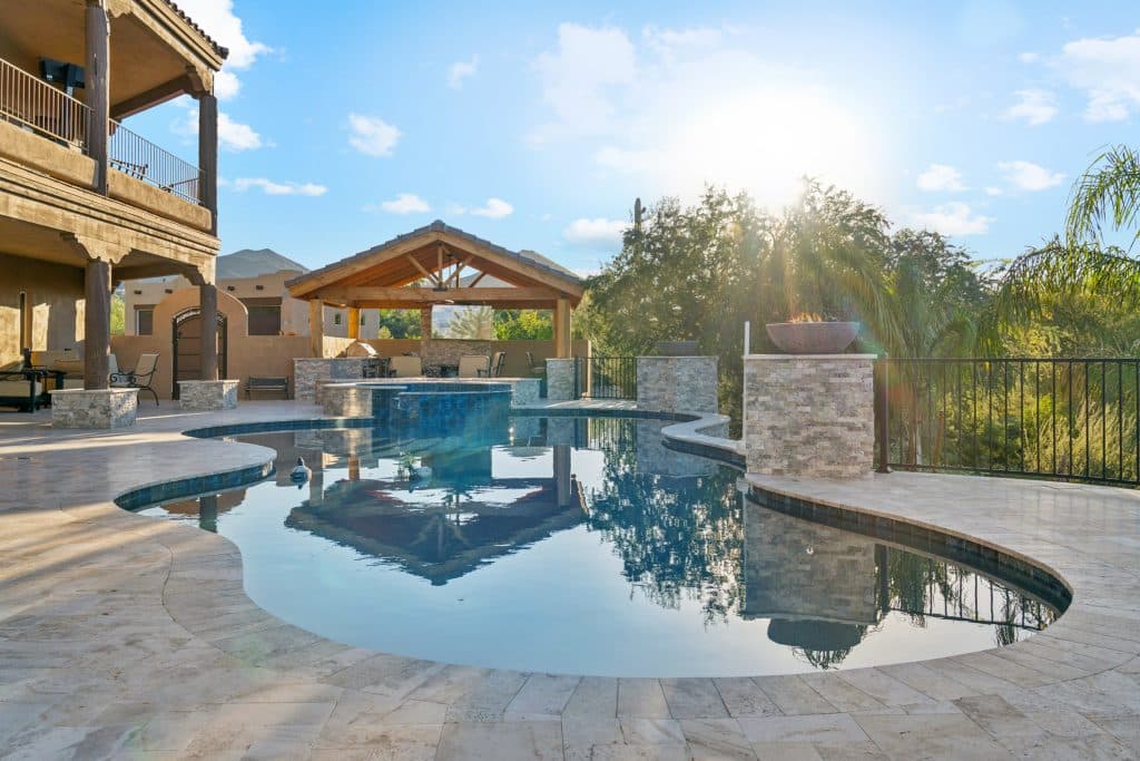 Sparkling blue pool glistens as the sun rises in the background